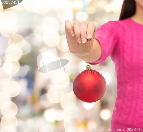Image of close up of woman in sweater with christmas ball
