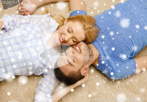 Image of happy couple lying on floor head to head at home