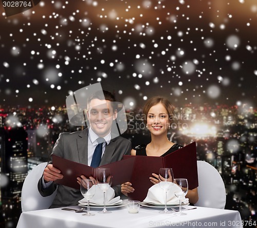 Image of smiling couple with menus at restaurant