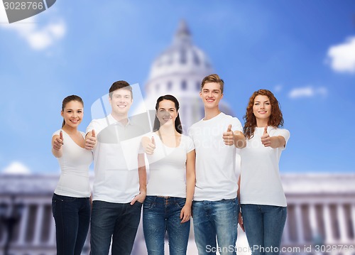 Image of smiling teenagers in t-shirts showing thumbs up