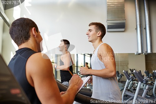 Image of men exercising on treadmill in gym