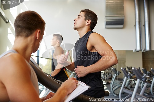 Image of men exercising on treadmill in gym
