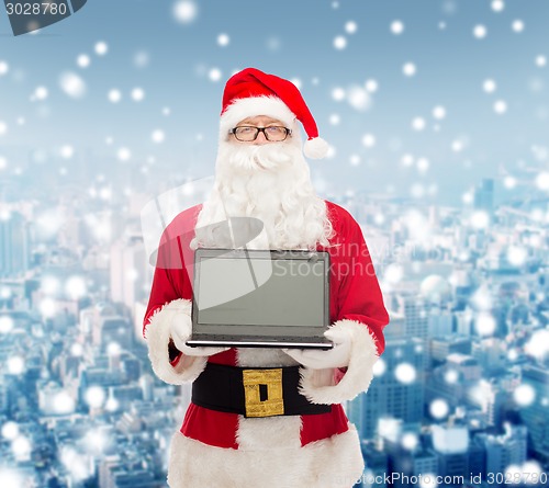 Image of man in costume of santa claus with laptop