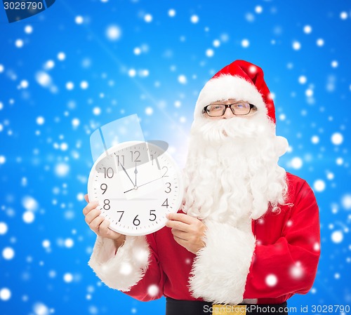 Image of man in costume of santa claus with clock