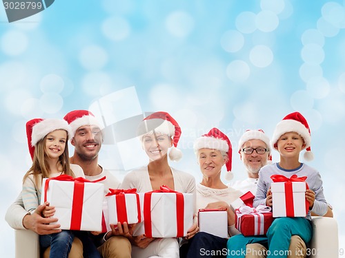 Image of happy family in santa helper hats with gift boxes