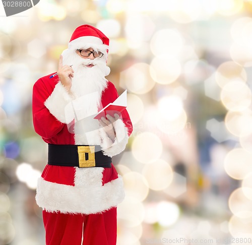 Image of man in costume of santa claus with notepad