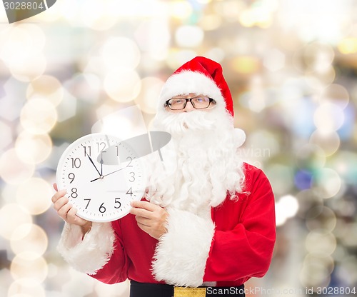 Image of man in costume of santa claus with clock