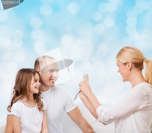 Image of happy family with camera at home