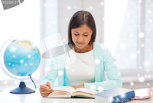 Image of smiling young woman with globe and tablet pc