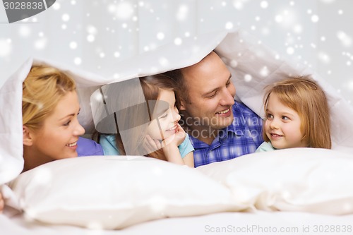 Image of happy family with two kids under blanket at home