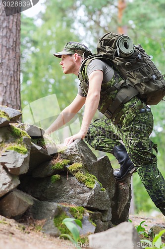 Image of young soldier with backpack in forest