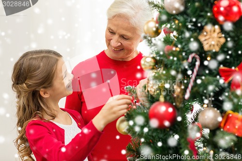 Image of smiling family decorating christmas tree at home