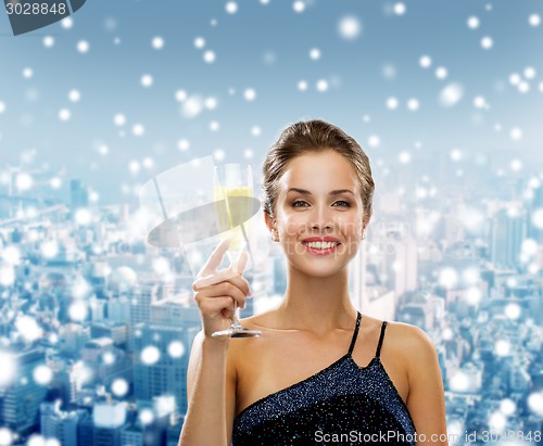 Image of smiling woman holding glass of sparkling wine