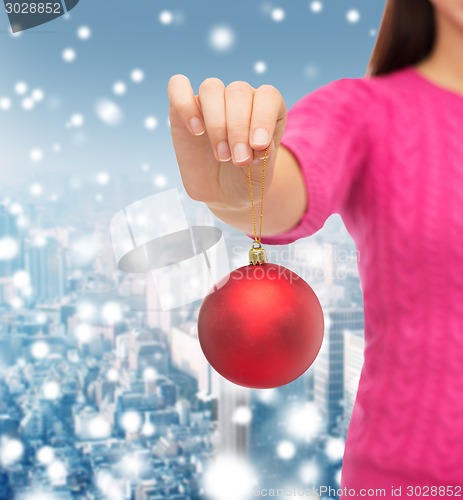 Image of close up of woman in sweater with christmas ball