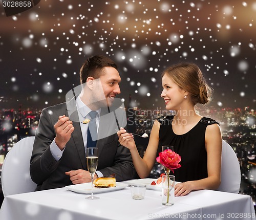 Image of smiling couple eating dessert at restaurant