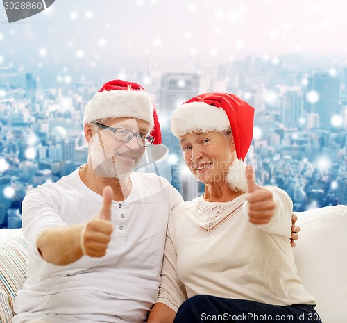 Image of happy senior couple in santa helper hats