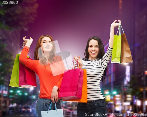 Image of two smiling teenage girls with shopping bags