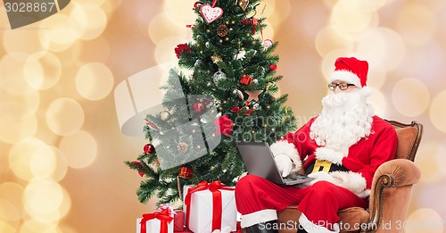 Image of man in costume of santa claus with laptop