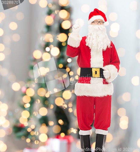 Image of man in costume of santa claus pointing finger up