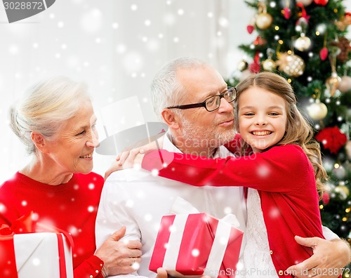 Image of smiling family with gifts at home