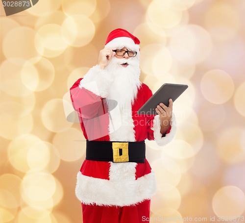 Image of man in costume of santa claus with tablet pc