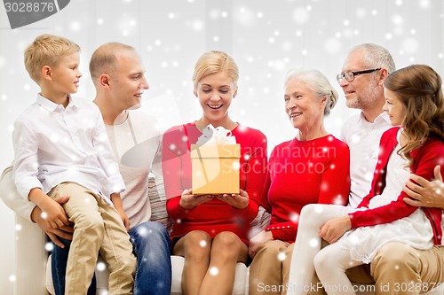 Image of smiling family with gifts at home
