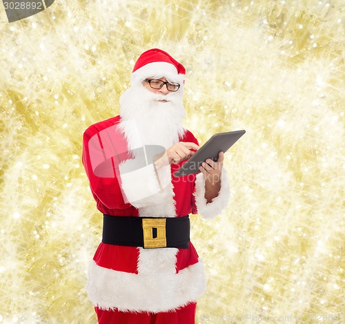 Image of man in costume of santa claus with tablet pc