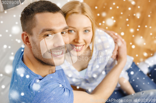 Image of happy couple hugging at home