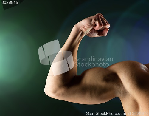 Image of close up of young man flexing and showing biceps