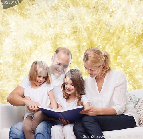 Image of happy family with book at home