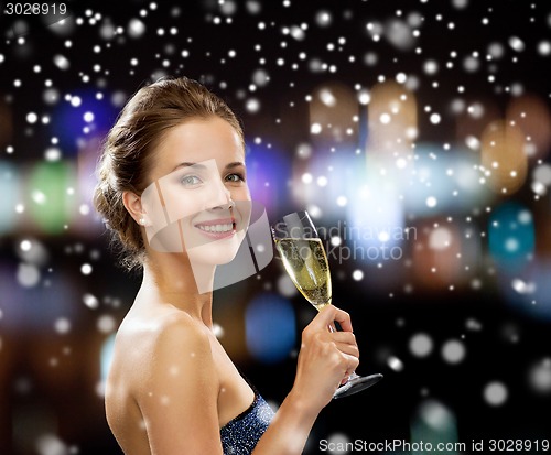 Image of smiling woman holding glass of sparkling wine