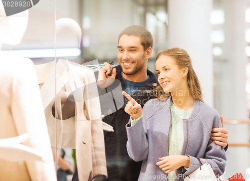 Image of happy young couple with shopping bags in mall