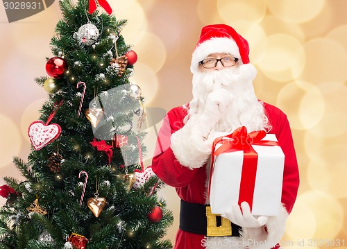 Image of man in costume of santa claus with gift box