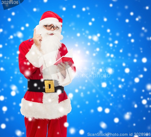 Image of man in costume of santa claus with notepad