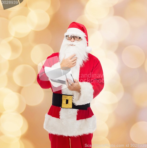 Image of man in costume of santa claus with notepad