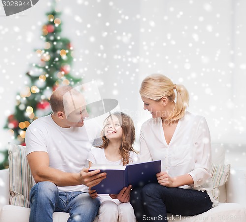 Image of happy family with book at home