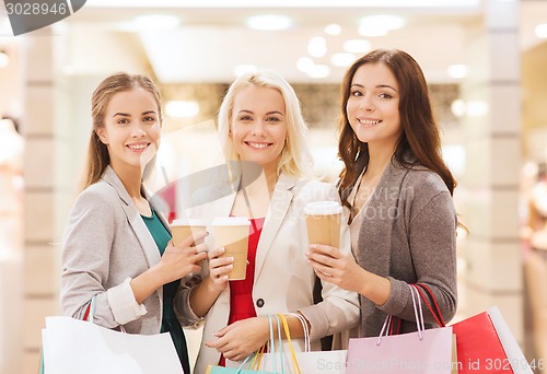 Image of young women with shopping bags and coffee in mall