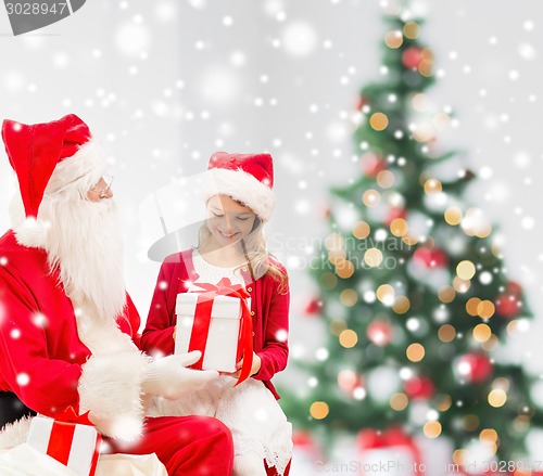 Image of smiling little girl with santa claus and gifts