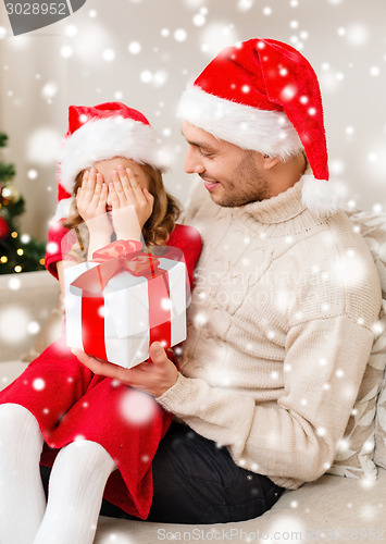 Image of smiling father and daughter holding gift box