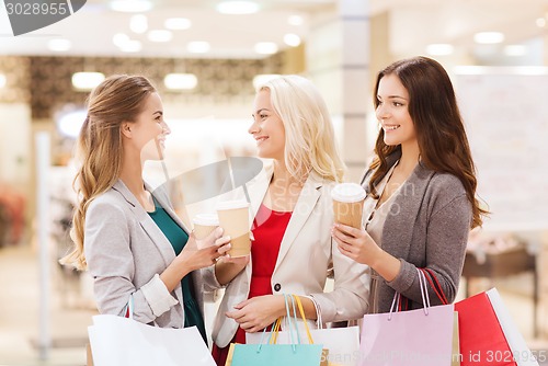 Image of young women with shopping bags and coffee in mall
