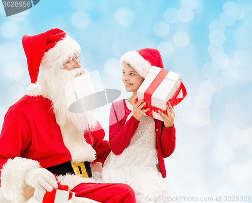 Image of smiling little girl with santa claus and gifts