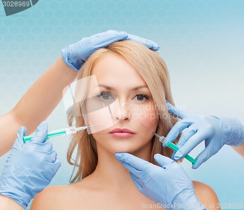 Image of woman face and beautician hands with syringes