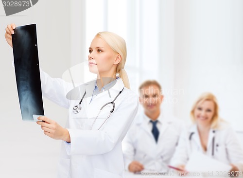 Image of serious female doctor looking at x-ray