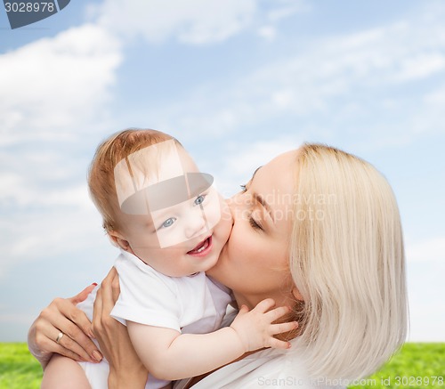 Image of happy mother kissing smiling baby