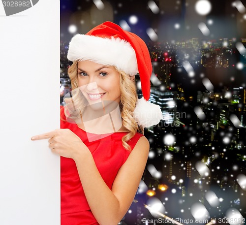 Image of smiling young woman in santa hat with white board