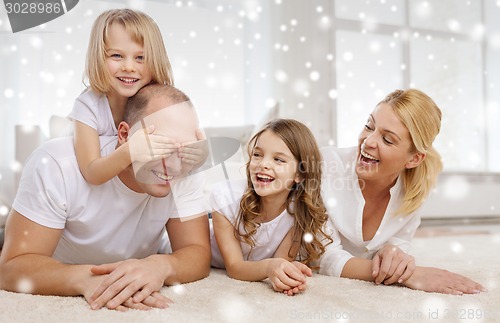 Image of smiling parents and two little girls at home