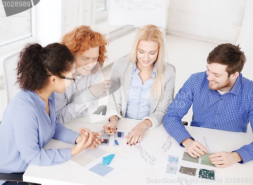 Image of smiling creative team looking at sketch