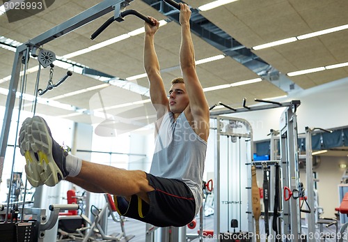 Image of man flexing abdominal muscles on pull-up bar