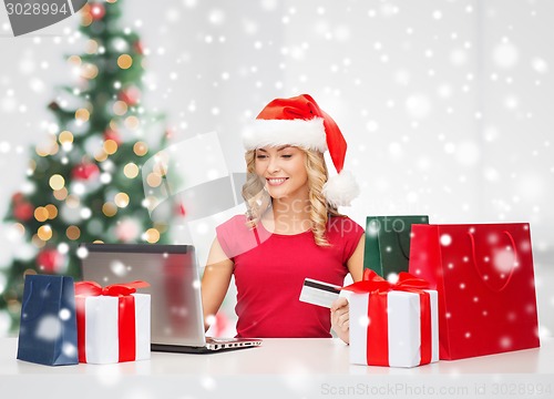 Image of woman with gift boxes and laptop computer