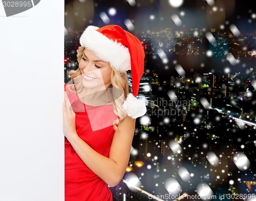 Image of smiling young woman in santa hat with white board